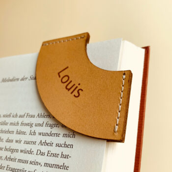 Leder Lesezeichen Natur Lesezeichen aus Leder mit einer Gravur. Das Lesezeichen ist auf eine Buchseite gesteckt.